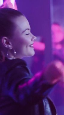 Mutlu kutlamalar. Neon ışıklı kadın. Sudents partisi. Gece kulübünde mor ışıkta dans eden bir kadına ilham verdi. Dikey video.