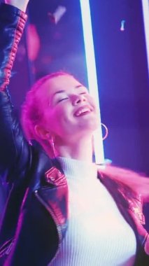 Neon ışıklı kadın. Dansın tadını çıkarıyorum. Mutlu bir parti. Konfeti yağmuru altında dans eden neşeli bayana ilham verdi. Dikey video.