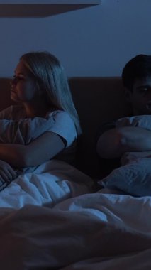 Gücenmiş bir çift. İlişki sorunu. Evlilik sorunu. Karanlik gece yatak odasinda birbirini görmezden gelen tatminsiz ask partnerleri. Dikey video.
