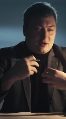 Sanal görüşme. İş koçluğu. Profesyonel uzmanlık. Karanlık işyerinde geç saatlere kadar konuşan başarılı, kendine güvenen bir yönetici. Dikey video.