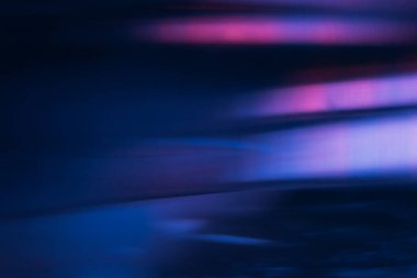 Bulanık ışık parlaması. Bokeh neon parıltısı. Geleceğe özgü bir parlaklık. Odaklanamayan ultraviyole lacivert pembe mor lekeler koyu modern soyut arka planda parlıyor..