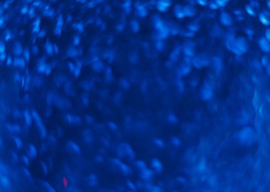 Bulanık ışık parlaması. Bokeh parıltısı örtüsü. LED aydınlatma yansıması. Odaklanmamış neon lacivert yuvarlak lekeler koyu modern soyut arka planda parıldıyor.