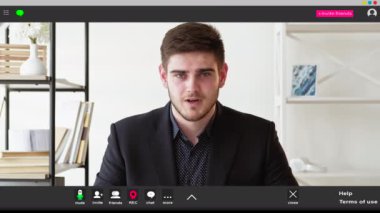 Online eğitim. Selamlayan adam. Ekran modeli. Pozitif zeki adam çalışma masasında oturuyor ve iç mekânda giysisi olan bir jest yapıyor..
