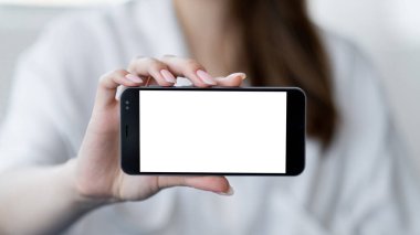 Sanal yaşam. Dijital bir model. Mobil bağlantı. Işıklandırma odasının iç kısmında elinde boş ekranlı akıllı telefon tutan tanınmayan bir kadın..