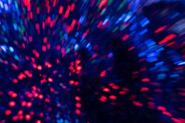 Bulanık neon ışık. Bokeh parıltısı. Havai fişek kıvılcımları. Odaklanmamış floresan lacivert kırmızı renk patlaması koyu siyah soyut arka planda çizgi hareketlerini parlatıyor.