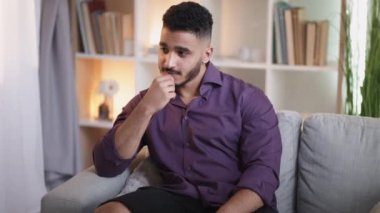 Düşünceli adam. Ev tefekkür. Yalnızlık endişesi. Üzgün, depresif, düşünceli, düşünceli bir adam, oturma odasındaki koltukta tek başına otururken çenesine dokunmayı düşünüyor..