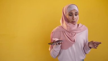 Payment failed. Mobile wallet problem. Bad banking service. Purchase cancel. Confused unhappy woman using phone credit card isolated on yellow copy space background.