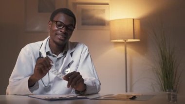 Sanal sağlık hizmeti. Video konferansı. Mesafe danışmanlığı. Kendine güveni tam bir erkek doktor. Modern ev içlerinde ilaç reçetesi yazıyor..