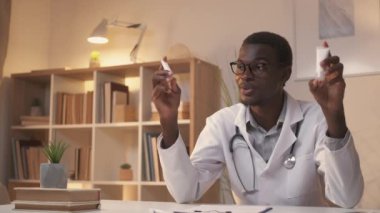 Tıp dersinde. İlaç üzerine çalışmalar. Uzaktan tıbbi eğitim. Kendine güvenen erkek dermatolog. İnternette öğretmenlik yapıyor. Modern ev içlerinde karşılaştırma kremi gösteriyor..