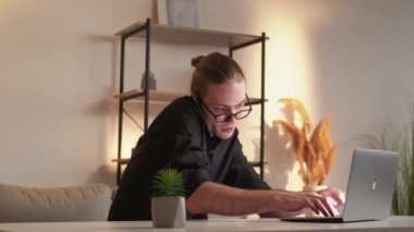 Corporate communication. Distance job. Business technology. Smart entrepreneur man working from home speaking on phone using laptop at virtual office workplace.