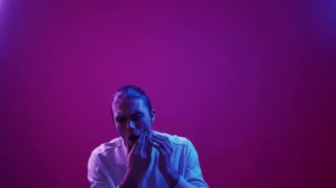 Toothache problem. Dental care. Cavity inflammation. Disturbed unwell guy suffering from pain touching jaw isolated on pink purple blue color copy space background.