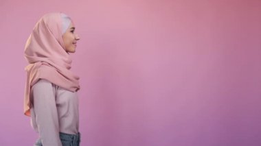 Happy woman. Good mood. Optimistic lifestyle. Side view portrait of pretty cheerful female in elegant hijab isolated on pink copy space advertising background.