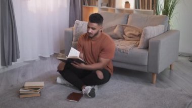 Kitap sever. Ev ödevi. Hafta sonu tatili. Modern oturma odasındaki sayfaları çeviren edebiyatla bağdaş kurmuş meraklı, zeki bir adam..