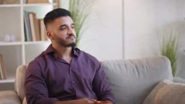 Kahve molası. Sabah ilham geldi. Ev tatili. Tatmin olmuş, kendine güvenen bir adam kanepede kanepede sıcak içecekten keyif alıyor..