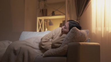 Ev istirahatı. Tatlı rüyalar. Boş zamanlarımızda. Rahatlamak için. Rahat sakin bir kadın, yumuşak yastıklarda sıcak battaniyenin altında rahat bir kanepede uyuyor..