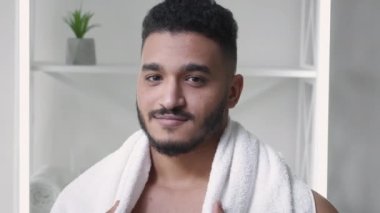 Sabah bakımı. Yüz derisi. Tazelik hijyeni. Sakallı, omuzlarında beyaz havluyla kendinden emin yakışıklı bir adam yüzü..