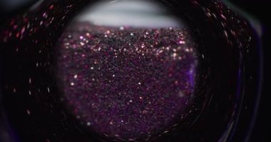 Glitter vortex. Blur sequin background. Fantasy hourglass. Purple pink color bokeh glow sparkles motion in defocused circle swirl frame on dark black shot on RED Cinema camera.