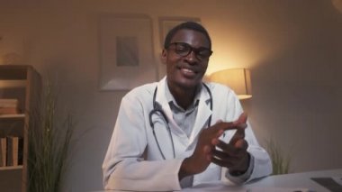 Doktor görüntülü konuşma. TeleHealth toplantısı. Sanal check-up. Modern ev içinde iyileşme gösteren hastayı alkışlayan mutlu erkek doktor..