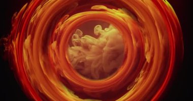 Color smoke circle. Ink water swirl. Space portal. Orange yellow fume filling round symmetrical tunnel on dark black abstract background shot on RED Cinema camera.