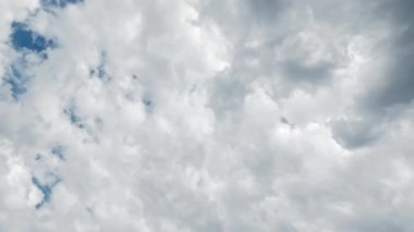 Cloudy sky. Weather change. Aerial view. White dense fluffy clouds covering bright blue heaven flying away fast motion.