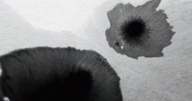 Ink water blot. Black paint drop. Transition overlay. Dark wet stain spatter on white grain texture copy space grunge abstract background.