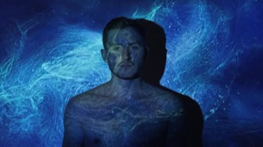 Man universe. Fantasy dream. Spiritual freedom. Peaceful relaxed calm shirtless man silhouette in blue mist cloud abstract galaxy stardust projector light.