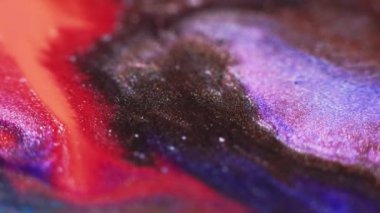 Ink floating. Sparkling color mix. Glitter paint blend. Blur neon red brown purple shimmering fluid pour motion abstract art background.