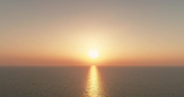 Morning sea. Drone view. Nature paradise. Seascape tranquility. Sunlight reflection on water surface relaxing motion pastel orange color sunrise sky background aerial shot.