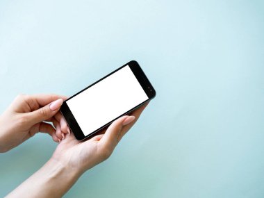 Mobile technology. Digital information. Advertising mockup. Female hand holding smartphone with blank screen isolated blue copy space.
