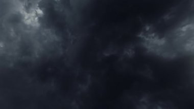 Black cloudy sky. Storm weather. Aerial view. Thundery dark dense clouds covering heaven flying through fast motion.