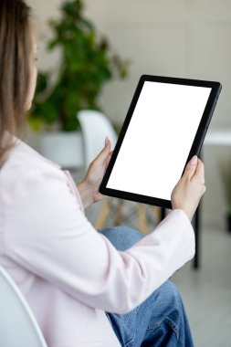 Virtual conference. Stylish woman. Computer mockup. Unrecognizable elegant lady holding tablet computer with blank screen in light room interior.