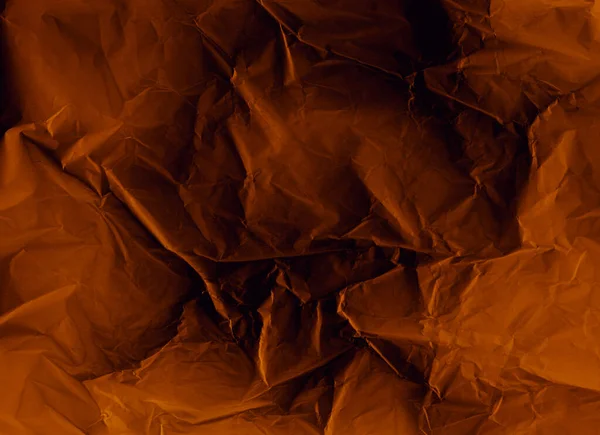 Creased paper texture. Grunge overlay. Distressed photo editor mask. Orange black crumpled wrinkled noise on dark illustration abstract background.