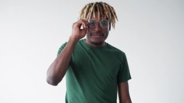 Flirting man. Meme expression. Stylish look. Handsome smiling black guy taking off spectacles winking isolated white looped video.