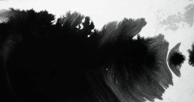 Black ink splatter on white paper. Dye blob. Ripped edge texture overlay. Liquid paint stain on rough grunge abstract background with defocused motion blur.