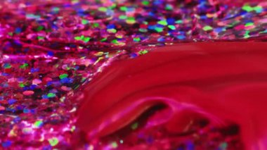 Abstract painting. Passion feelings. Creative art. Bright red fluid paint floating and mixing together with transparent colorful glittered texture in macro shooting.