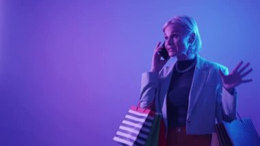 Customer complaint. Bad service. Shopping feedback. Frustrated angry woman client disappointed with fake product purchase arguing on phone call in neon light copy space.