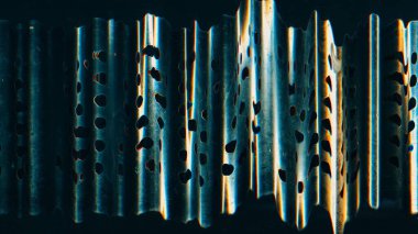 Glitch noise. Distressed overlay. Weathered surface layer. Blue yellow color rusty stained perforated metallic texture on dark black illustration abstract background.