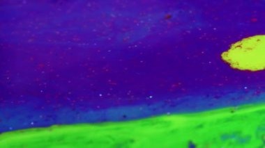 Abstract painting. Acrylic magic. Creative art. Light green fluid paint stream floating and mixing together with glittered violet in macro shooting.
