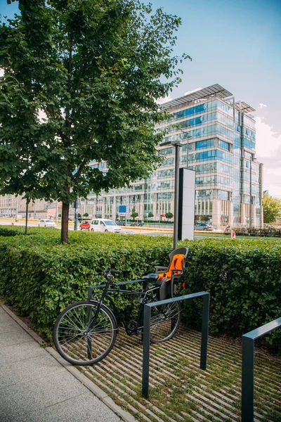 Public share service. Mobile transport. City vehicle. Single bike with child chair in parking zone on street daylight.