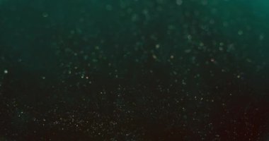 Bokeh sparks overlay. Blur circles texture. Glitter floating. Defocused teal blue golden particles motion on dark color gradient abstract vertical background. Shot on RED Cinema camera.