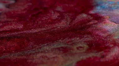 Glitter art. Abstract design. Colorful paint background. Red glitter colors blend.