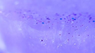 Multicolor glitter sparkles on lavender blue. Smeared defocused abstract color art background