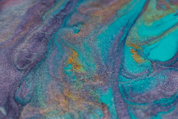 Mixing colors. Fluid magic. Creative painting. Cyan blue purple gold stream of liquid paint floating. Marble effect