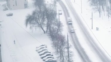 Heavy urban snowfall. Winter storm on the road. Wet blurry street with city traffic shot from above