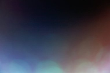 Bokeh light leak. Lens flare. Blur soft glare. Optical radiance. Defocused orange blue purple color glow on dark abstract copy space background.