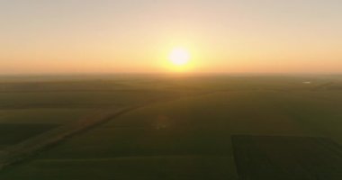 New day begining. Sun rising above harvested agriculture lands. Endless landscape of late summer morning