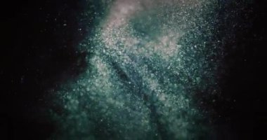 Glitter dust swirl. Particles background. Bokeh light circles texture. Defocused green blue orange bubbles splash on dark black abstract vertical overlay. Shot on RED Cinema camera.