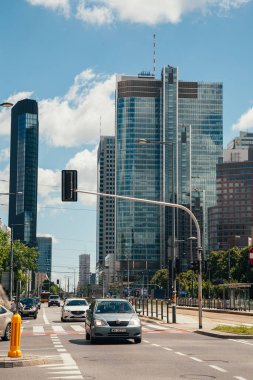 Warsaw, Poland - June 22, 2022: Road traffic. City landmark. Downtown industry. Street view with modern skyscraper crossroad riding cars in sunny daylight.