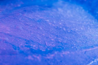 Blue paints on melting ice. Flowing liquid inks. Nature glacier. Creative art process