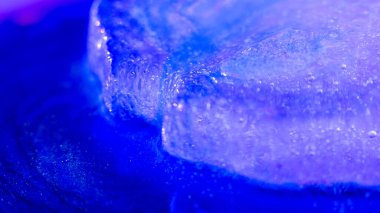 Global warming. Melting blue ice macro shot. Natural crystal clear flowing water. Creative background